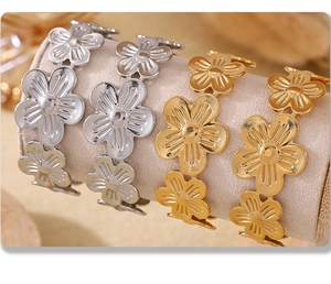 Detailed view of floral stainless steel bracelets in gold and silver on a jewelry display