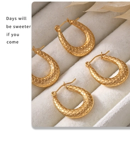 Close-up of 18K gold plated U-shaped hoop earrings with textured snakeskin finish