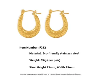 Detail view of U-shaped gold earrings with honeycomb texture, 23mm size and 7.6g weight