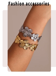 Macro shot of gold and silver stainless steel five-petal flower bangles worn on a wrist