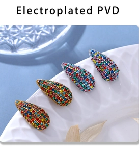 Macro detail of PVD plated drop earrings featuring multi-color pavé rhinestones