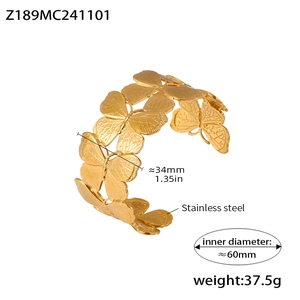 Vue macro du bracelet jonc en acier inoxydable doré avec détails d'ailes de papillon