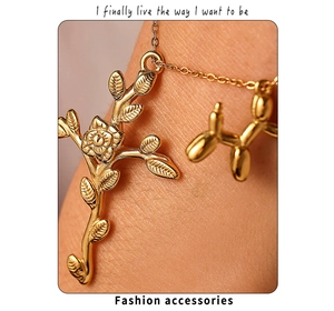 Macro shot of 18K gold plated rose cross and balloon dog pendant necklace