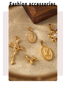 Close-up of vintage 18K gold plated charms including cross and balloon dog on linen