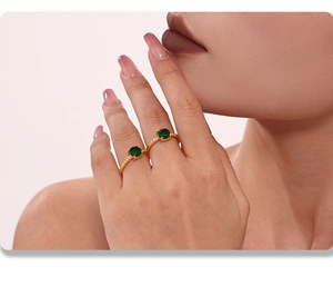 Close-up of dual emerald zircon rings with gold plating on model fingers