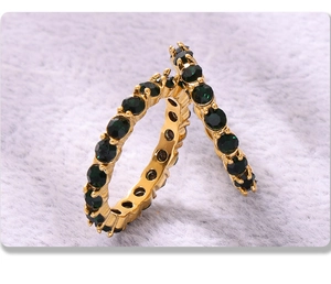 Vista macro degli orecchini placcati oro 18K con inserti in pietra verde smeraldo