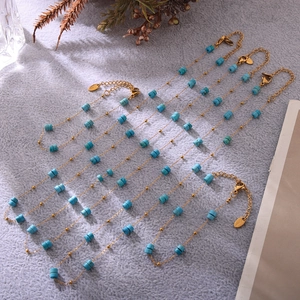 Détail de perles turquoise avec chaîne en acier inoxydable doré et fermoir mousqueton