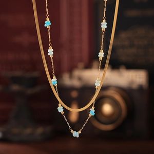 Détail du collier double rang doré avec chaîne serpent et perles en pierre bleue