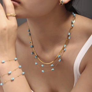 Parure bohème avec collier multi-rangs doré et bracelet sertis de perles en pierre bleue