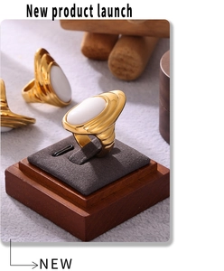 Detail van een PVD 18K vergulde ring met golvende textuur en opaalachtige witte steen
