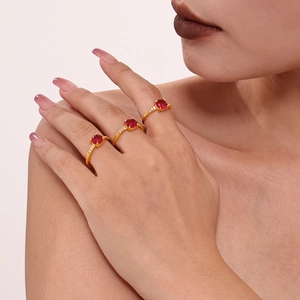 Three-piece set of gold-plated rings with oval red zircons and four-prong setting