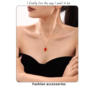Détail d'un collier pendentif chaussette de Noël avec zircon rouge et chaîne dorée