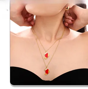 Détail de colliers avec pendentifs de bas de Noël rouges portés par un mannequin