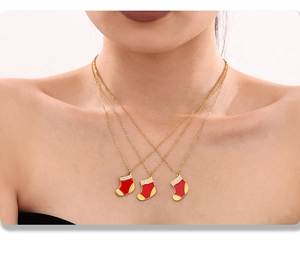 Gros plan du collier chaussette de Noël doré avec émail rouge et zircons brillants