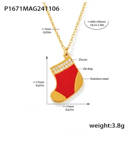 Détail macro du pendentif chaussette de Noël en acier avec zircon et goutte d'huile rouge
