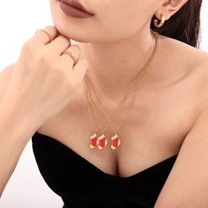 Collier pendentif chaussette de Noël dorée avec émail rouge et zircon sur modèle