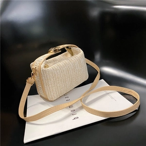 Close-up of cream woven handbag featuring a metal turn-lock and fine strap texture