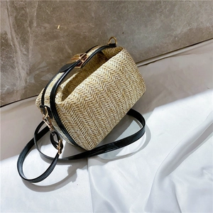 Macro view of woven straw texture and leather strap with gold buckle on crossbody bag