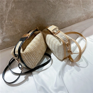 Detail of woven straw crossbody bags with gold hardware and PU leather trim straps