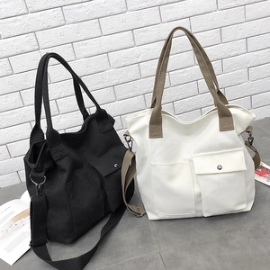 Detail of minimalist canvas crossbody bag featuring functional dual front utility pockets