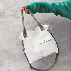 Off-white canvas messenger tote bag with brown straps and utility front pockets
