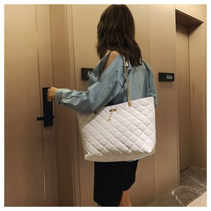 White quilted chain tote bag with deer pendant shown on a model for size and fit