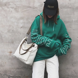 Detail of minimalist white canvas tote bag styled with a casual streetwear outfit