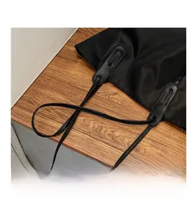 Detail of the reinforced leather handle base and black nylon fabric on a tote bag