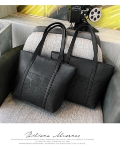 Detail of black tote bags featuring floral embossing and classic diamond quilting textures