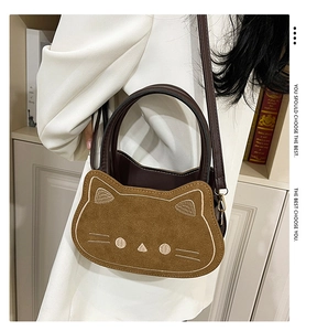 Detail of cute cat crossbody bag showing suede cat face embroidery and brown leather strap
