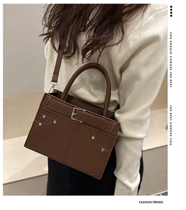 Détail d'un sac à main en cuir marron avec boucles argentées et rivets stylés
