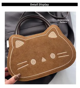 Detaillierte Nahaufnahme der Katzenstickerei und Plüschtextur auf der braunen Handtasche