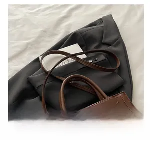 Détail de la texture en cuir marron et boucle métallique réglable sur un sac rétro chic