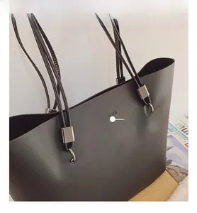 Makroaufnahme der schwarzen matten Tragetasche mit FASHION-Prägung und Multi-Riemen-Design