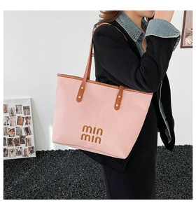 Close-up of pink woven canvas tote bag with brown leather straps and min min embroidery