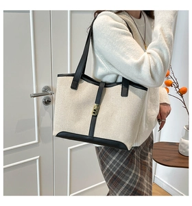Detail of canvas tote bag with black leather trim and elegant gold metal snap closure