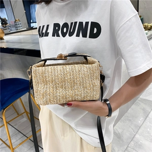 Fashionable woven straw crossbody bag with black handle and gold lock hardware