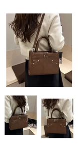 Detail view of the brown retro shoulder bag showing smooth matte texture and metal rivets