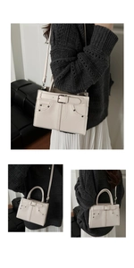Detail of cream white leather handbag with metal buckle and rivet accents for women
