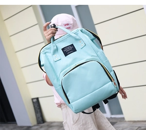 Detail of mint green large capacity diaper backpack with Living Traveling Share label