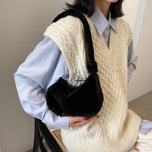 Chic black faux fur crossbody bag with knot handle detail shown on a female model