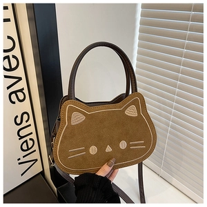 Detail der niedlichen braunen Wildleder-Handtasche in Katzenform mit Stickerei und Kunstledergriffen