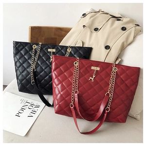 Detail of quilted tote bags in black and wine red with gold chain and deer pendant