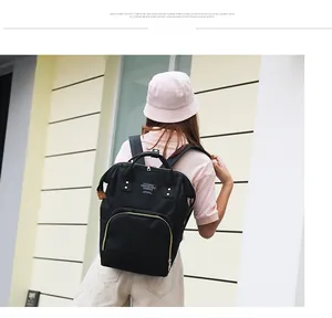 Outdoor view of a black multi-functional diaper backpack with adjustable shoulder straps