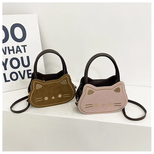 Macro detail of embroidered cat face and premium suede texture on mini crossbody bags