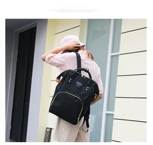 Detail of a black large-capacity mommy backpack with wide opening and gold zippers