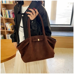 Gros plan d'un grand sac fourre-tout en daim marron avec boucle carrée dorée en bibliothèque