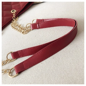 Detail of burgundy quilted leather handbag with gold-tone metal chain and leather strap