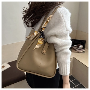 Detail of khaki tote bag with a silk scarf handle wrap, showing premium matte PU leather texture