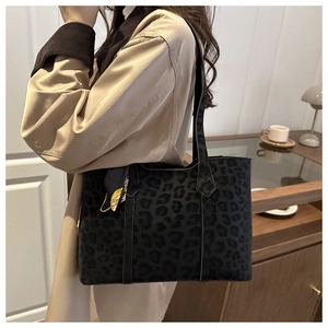 Close-up of leopard print tote bag in black suede with decorative silk scarf on the strap